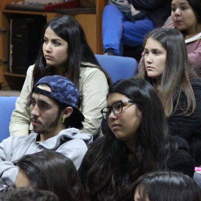 Cuatro alumnos y alumnas observan la charla.