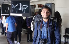 El estudiante Joaquín López delante las fotos que forman parte de la exposición.