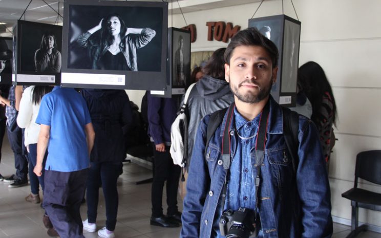 El estudiante Joaquín López delante las fotos que forman parte de la exposición.
