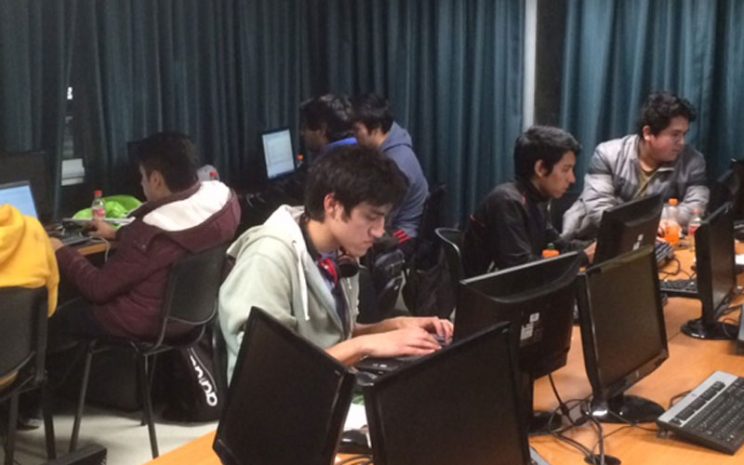 Grupo de alumnos trabajan en sus computadores durante el evento.