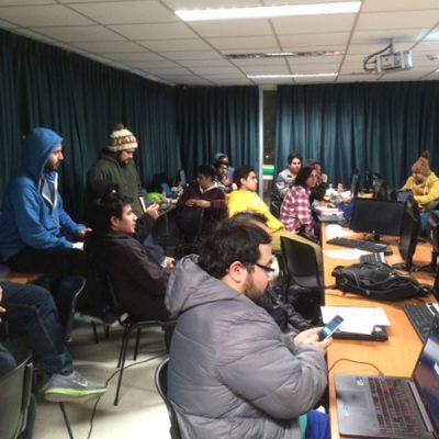 Vista general del evento, donde se aprecia a los participantes trabajando en los computadores.