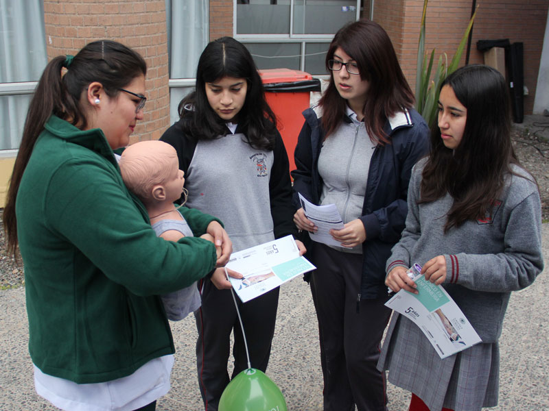 Estudiante deTécnico en Enfermería enseña primeros auxilios a alumnas.