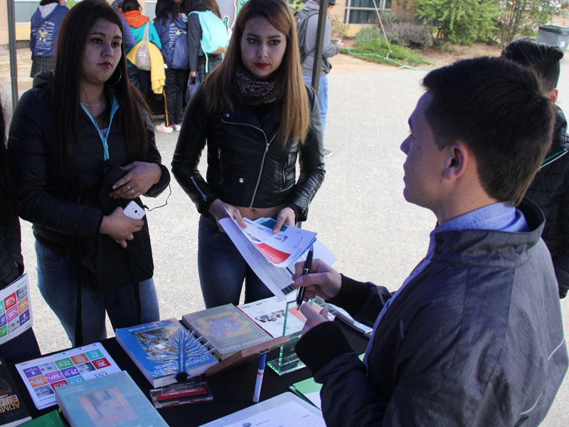 Alumno de Ingeniería Comercial entrega información a dos alumnas.