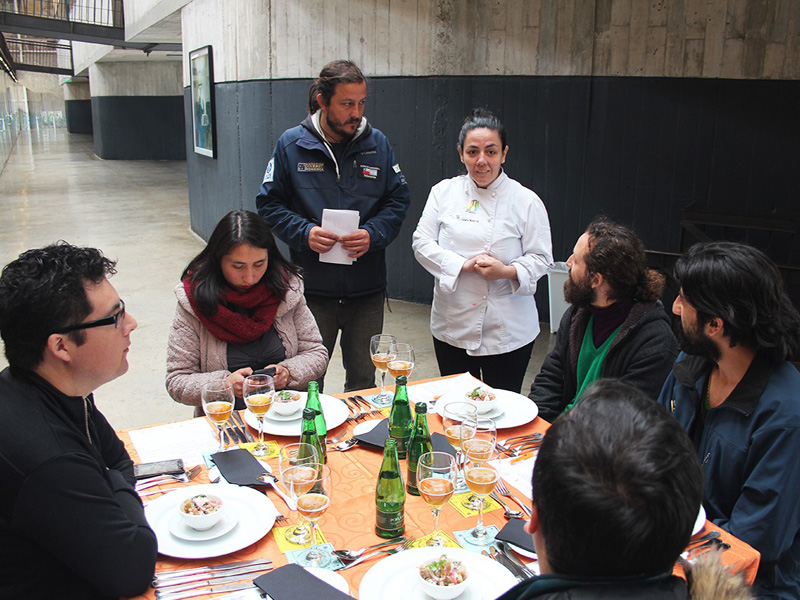 Francisco Fantini junto a una chef, presentando los platos a los asistentes
