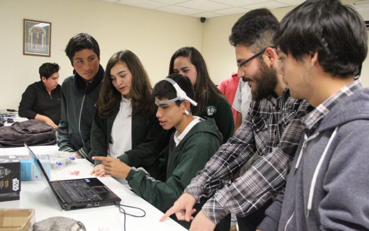 Estudiantes de Informática enseñan la utilización de un sensor a un alumno del Colegio Santo Tomás.