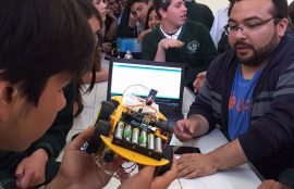 Un alumno del colegio observa los detalles de uno de los robots.