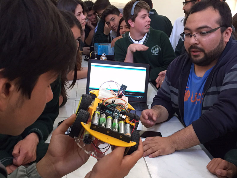 Un alumno del colegio observa los detalles de uno de los robots.