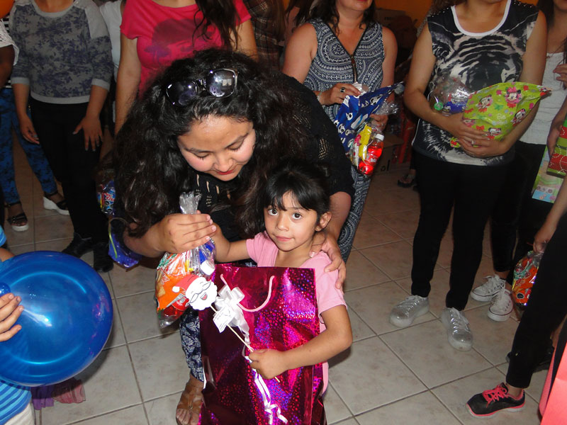 Una de las niñas recibe uno de los regalos.