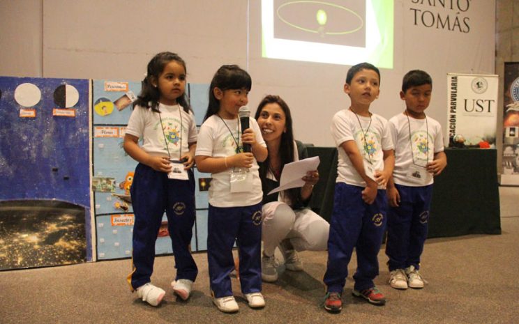 Cuatro niños, apoyados por su educadora, se presentan en el evento.