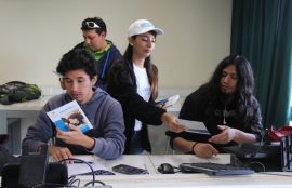 Promotora entrega información a estudiantes del área de Electrónica.
