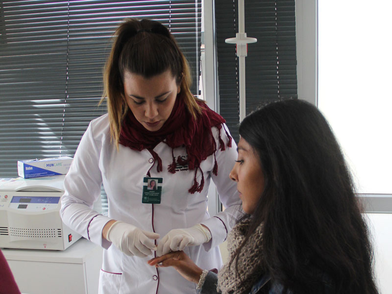 Alumna es parte de exámen previo para establecer su grupo sanguíneo.