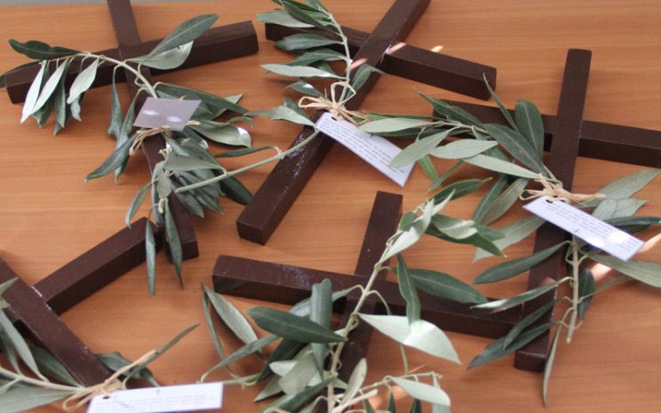 Cruces junto a mensajes y ramos de olivo entregados a los participantes de la reflexión.