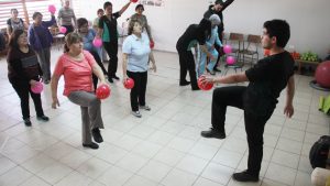 Adultos mayoers realizan ejercicios bajo la guía de Aldo Olivares. 