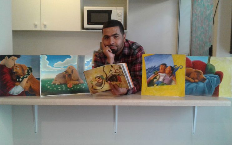 Roberto junto a algunos de sus libros e ilustraciones.