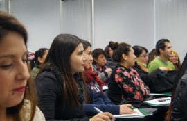 Ex alumnas de Santo Tomás miran atentas la exposición sobre IAAS y REAS.