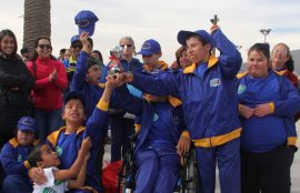 Niños y niñas de una escuela especial sostienen una copa que representa su participación en la tercera versión de las olimpiadas inclusivas.