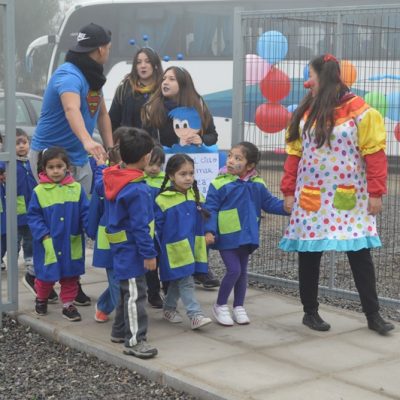 Un grupo de niños ingresa al gimnasio de Santo Tomás Puente Alto, guiados por alumnos de Santo Tomás.