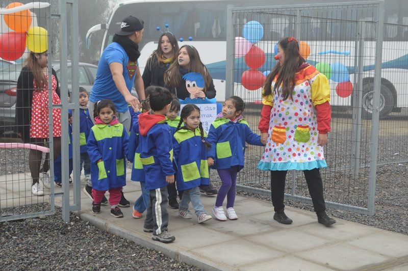 Un grupo de niños ingresa al gimnasio de Santo Tomás Puente Alto, guiados por alumnos de Santo Tomás.