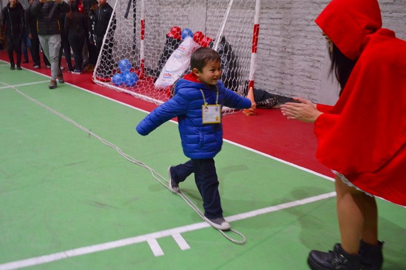 Un niño corre hacia una estudiante de Santo Tomás vestida como caperucita roja.