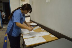 Isabel Silva, egresada de TEPAR, ordena fichas de pacientes durante su turno en el centro asistencial de ñuñoa.