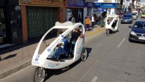 Dos triciclos del proyecto recorriendo la calle. 