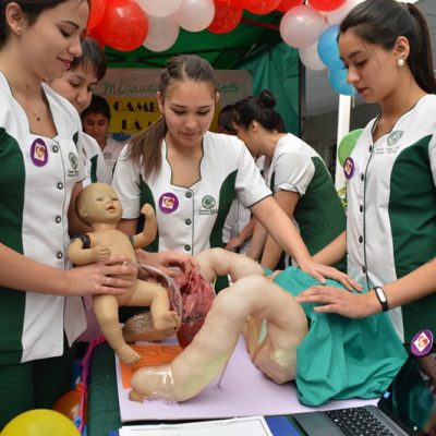 Alumnas simulan un parto con la ayuda de muñecas.