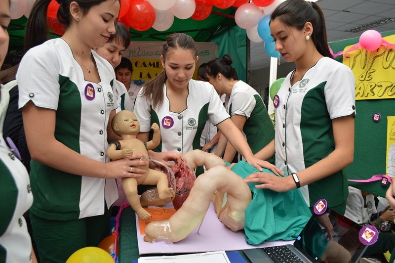 Alumnas simulan un parto con la ayuda de muñecas.