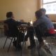 Niño trabaja en una mesa junto a dos alumnos de Psicología.
