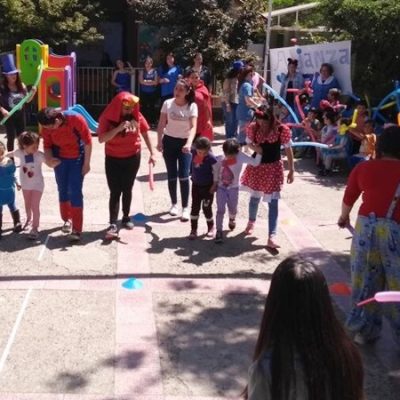 Alumnas de Santo Tomás, disfrazadas de superhéroes y personajes de Disney, animan concursos con niños y niñas en el patio de un colegio.