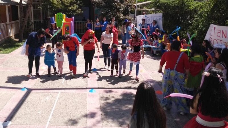 Alumnas de Santo Tomás, disfrazadas de superhéroes y personajes de Disney, animan concursos con niños y niñas en el patio de un colegio.