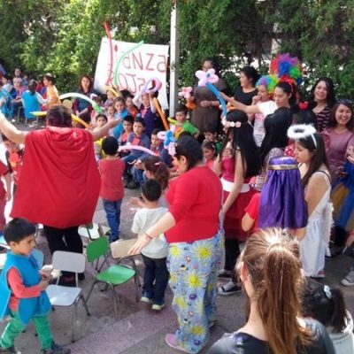 Alumnas de Santo Tomás, disfrazadas de superhéroes y personajes de Disney, animan concursos con niños y niñas en el patio de un colegio.