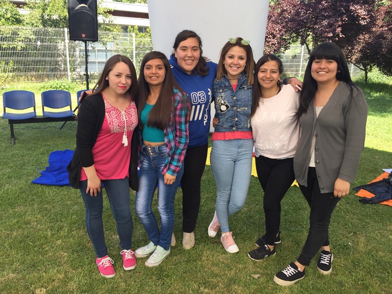 Seis alumnas posan frente a la cámara, sonriendo, en las canchas de pasto.