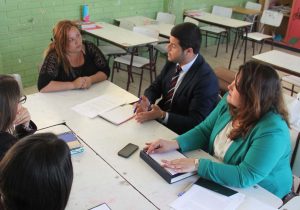 Estudiantes asesorando a una señora. 