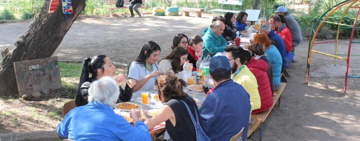 Estudiantes de Santo Tomás Puente Alto sentados a la mesa con participantes de la ONG Sonrisólogos, durante un almuerzo.